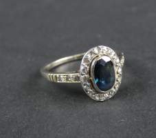 Bijou : Bague en or blanc 18K sertie d'un saphir ovale (usures) entouré de diamants taille rose