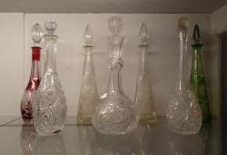 Verrerie : 7 carafes en cristal taillé incolore et couleur dont Bohème et Val Sait Lambert H : +/ - 42cm