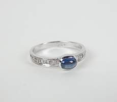 Bijou: Bague en or blanc 18K sertie d'un saphir cabochon d'env. 0,50cts et de di