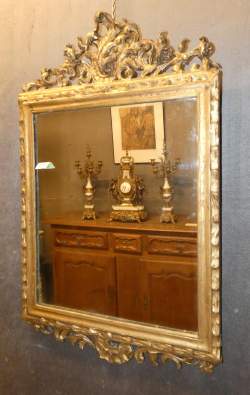 Meuble : Miroir avec cadre en bois sculpté probablement début 19eS décor de rinceaux végétaux et fronton ajouré