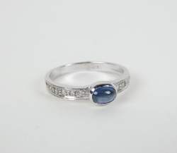 Bijou: Bague en or blanc 18K sertie d'un saphir cabochon d'env. 0,50cts et de di